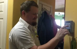 Kenny adjusting a wifi thermostat