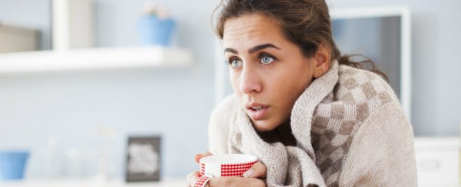Woman feeling chilly indoors and needs a heater check