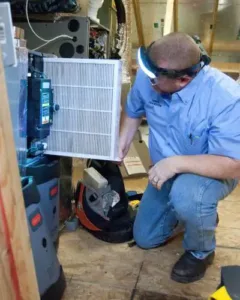 HVAC technician changing a filter in the attic