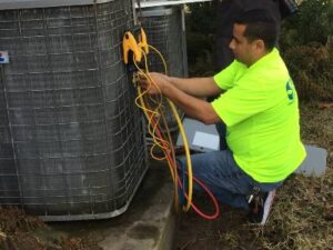 HVAC technician checking refrigerant charge on a condenser