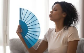 how-to-stay-cool-indoors-when-the-electricity-is-out-woman-using-handheld-fan
